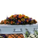 A white casket adorned with flowers