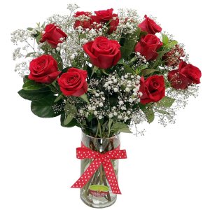 Glass vase filled with red roses, baby breath, and lush greenery