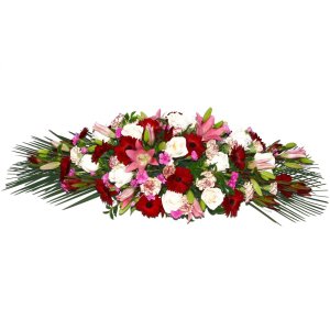 Elegant casket flowers featuring a large arrangement of red and white blooms