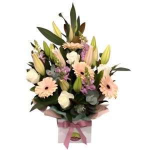 A stunning flower arrangement in a square box, featuring a mix of pink and cream flowers