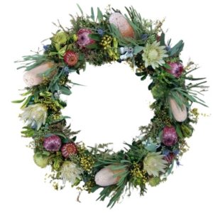 A wreath with flowers and greenery on a white background, symbolizing ANZAC Day memorials