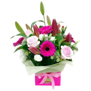 An elegant pink box adorned with a beautiful arrangement of white and pink flowers