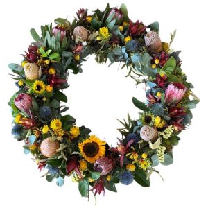 A white background showcasing an Anzac wreath adorned with flowers