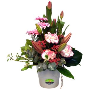 Colorful flowers arranged in a pot with lush greenery, creating a lovely display