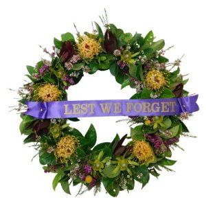 ANZAC wreath adorned with purple ribbon and flowers, symbolizing remembrance and honor