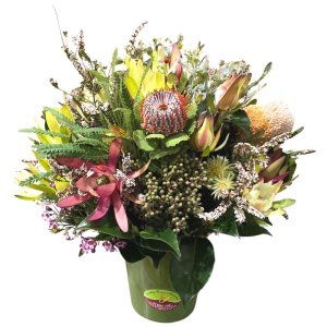 A flower arrangement in a big green vase showcasing a variety of colorful flowers