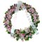 A sympathy wreath adorned with pink flowers and a white ribbon, symbolizing condolences and remembrance